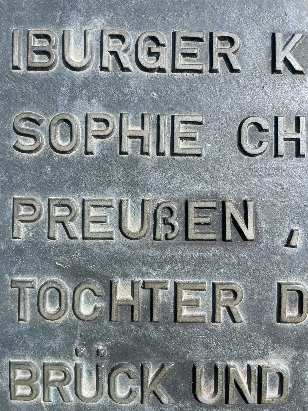 Eine Bronzetafel mit Inschrift. Im Wort Preußen mag das kleine SZ nicht so recht zwischen die Großbuchstaben passen.